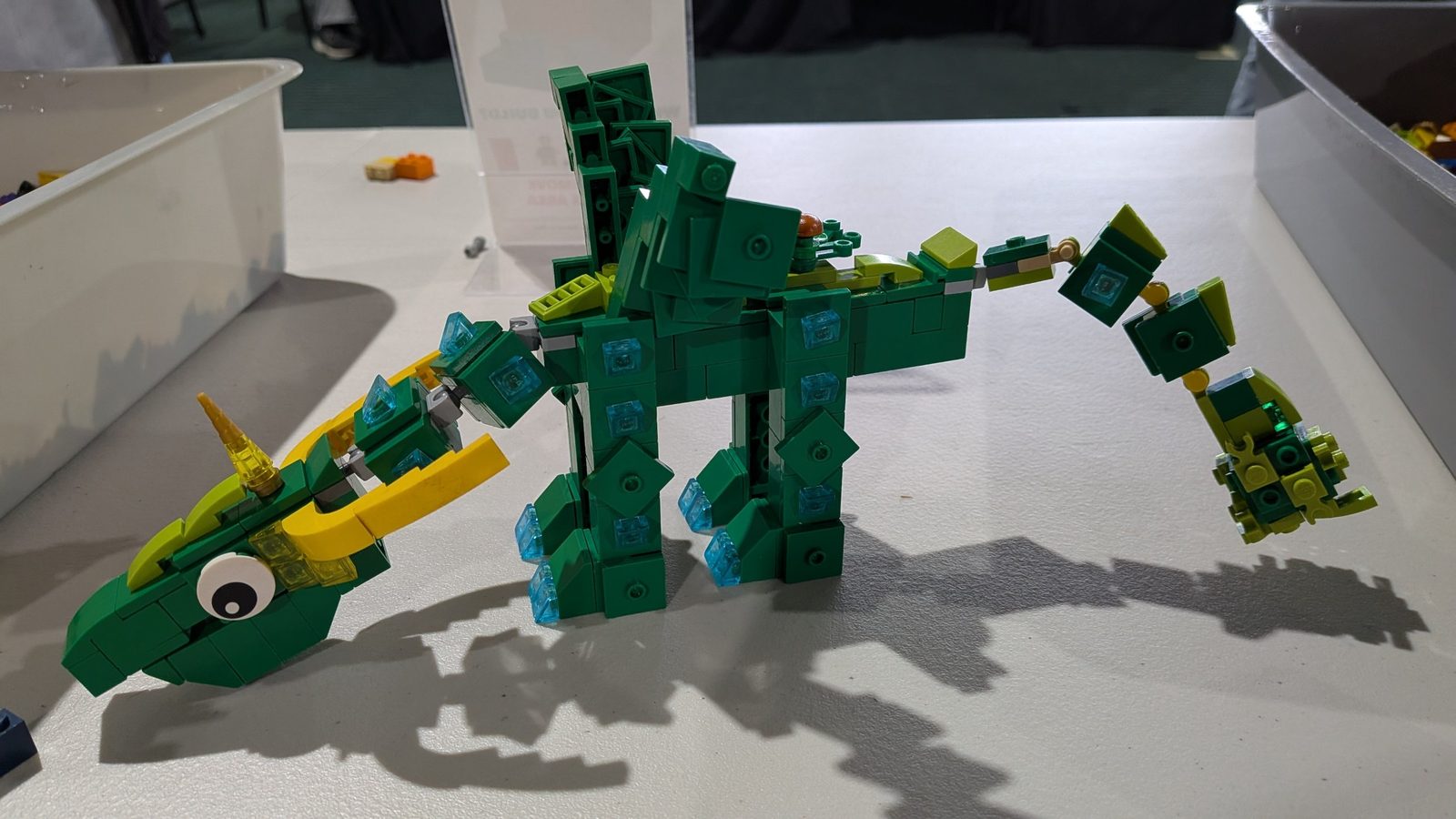 A green brick-built dinosaur on a table in the build area