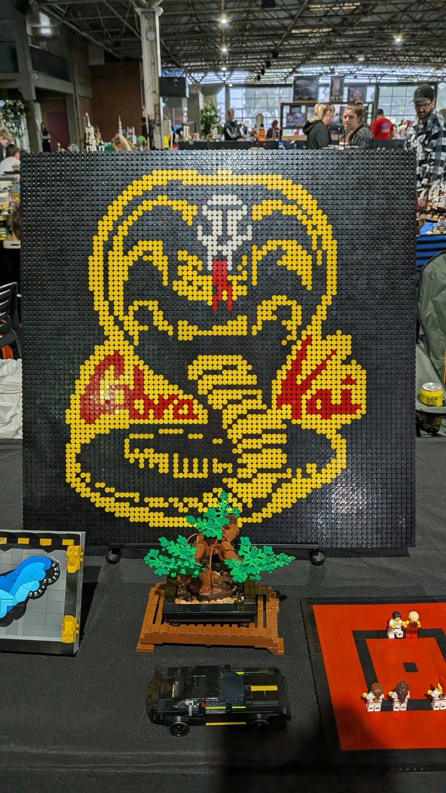A yellow, red and black Cobra Kai mosaic above a bonsai tree and a dojo scene