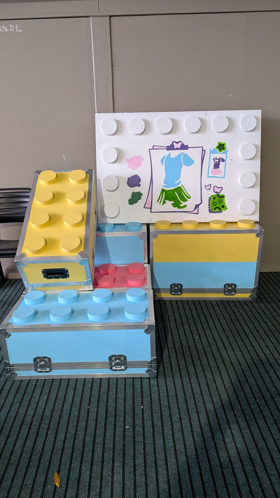 Road cases painted to look like giant yellow, blue and red LEGO bricks