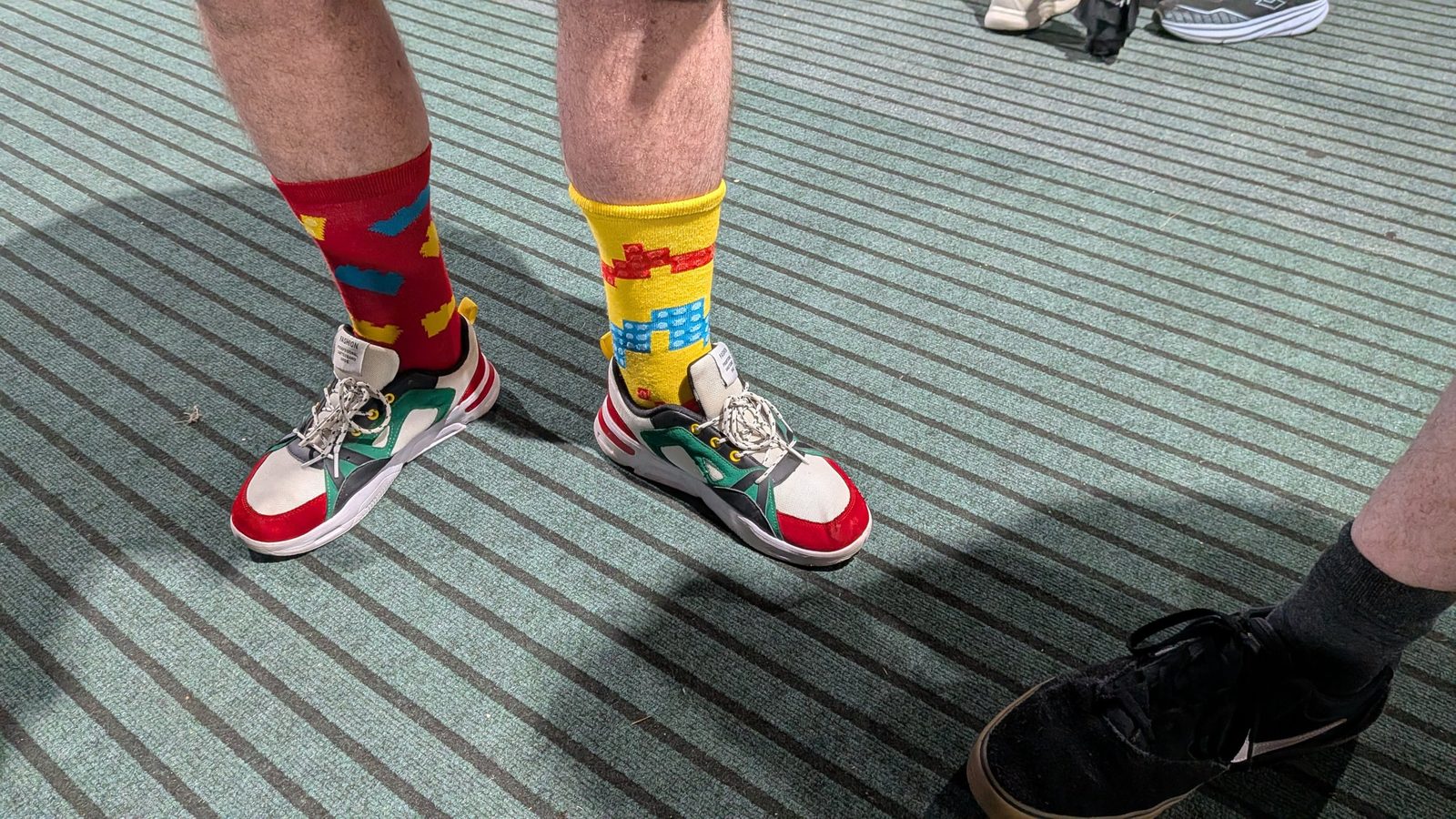 Mismatched red and yellow LEGO brick socks with colourful sneakers