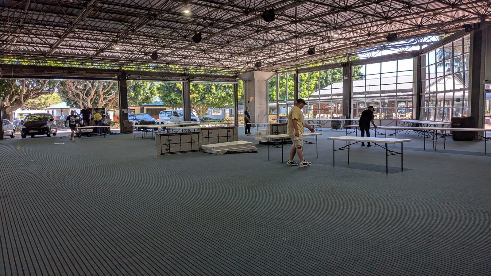 Volunteers setting up trestle tables in the empty hall before the event